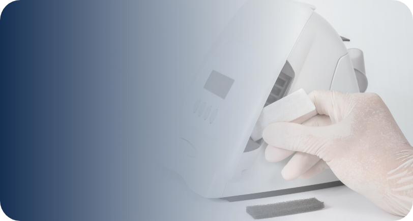 Osoba w rękawiczce czyści urządzenie medyczne chusteczką.