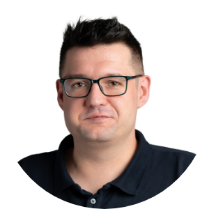 Mężczyzna w okularach patrzy prosto w obiektyw na białym tle.