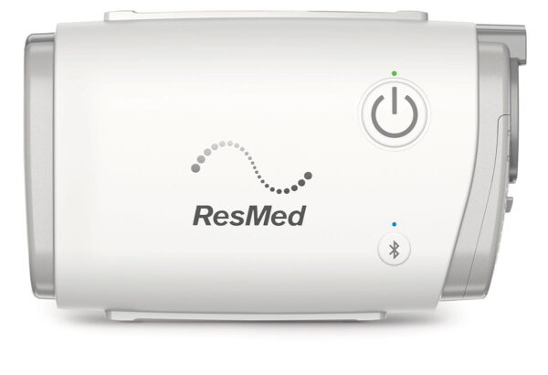Urządzenie medyczne ResMed z przyciskiem zasilania i symbolem Bluetooth na obudowie.
